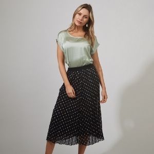 Black skirt with a polka dot print. This skirt has a black waistband and is pleated.