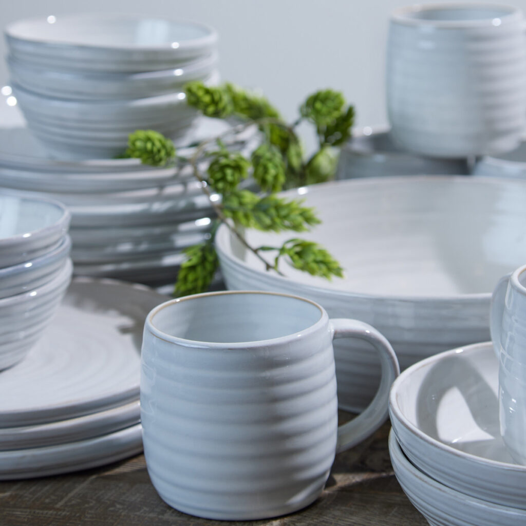stoneware dinner set with fully glazed finish and raised-line details. set includes bowls, platters, mugs and a jug.