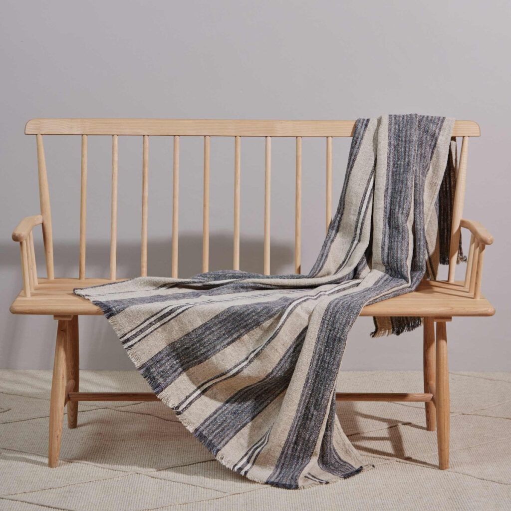 beige blanket with blue stripes made from linen, viscose, cotton and acrylic.